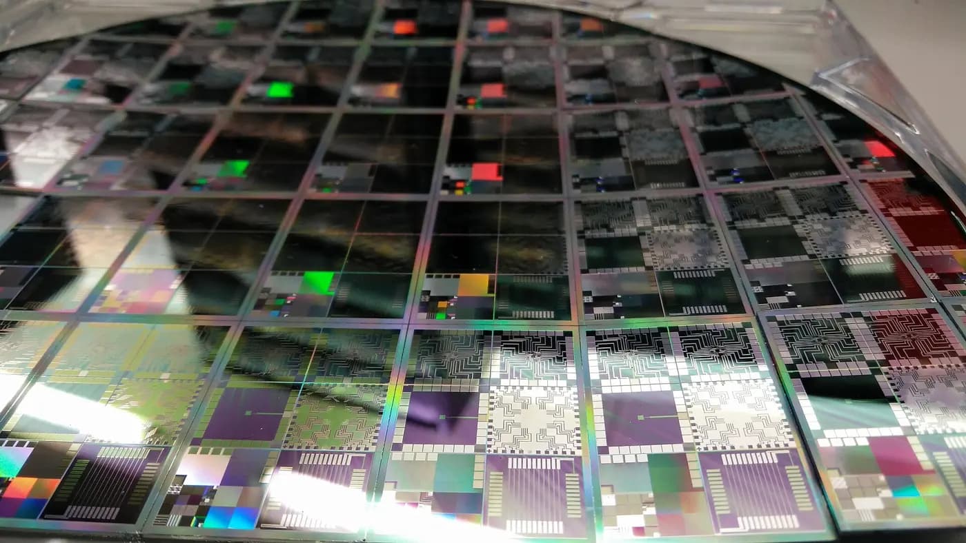 A silicon wafer etched with chips. Superconducting quantum processors such as Willow are also built flat, which shapes Google’s architecture choices.
